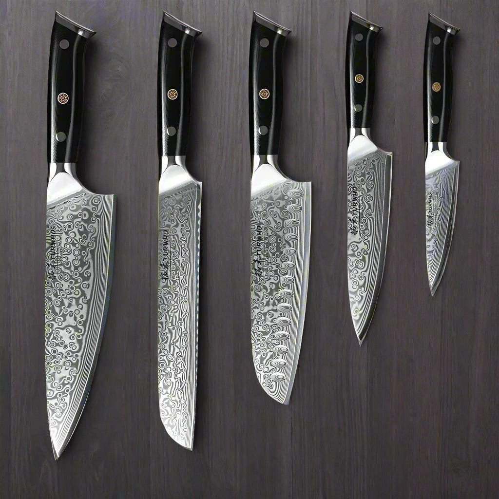 Set of five Damascus steel kitchen knives with black handles on a wooden background