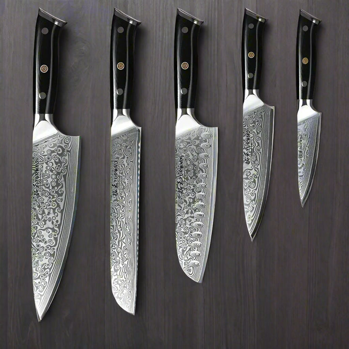Set of five Damascus steel kitchen knives with black handles on a wooden background